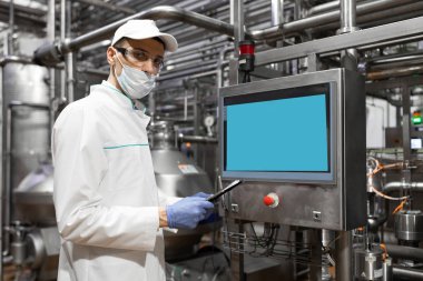 Süt fabrikasında üretim bölümü dururken gerekli notlar alarak teknoloji uzmanı