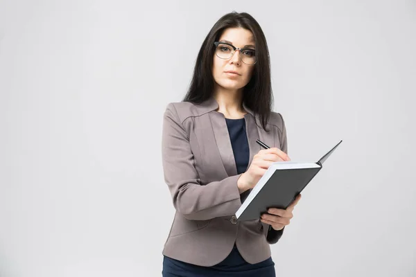 Retrato de una joven con gafas con un diario en las manos aislado sobre un fondo claro — Foto de Stock