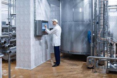adam beyaz bir elbise içinde ve bir kap dijital ekranın yakınındaysa standları