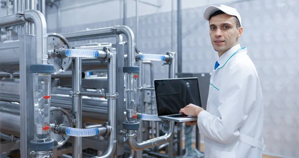 Süt fabrikasında onun elinde bir dizüstü bilgisayar ile teknoloji uzmanı — Stok fotoğraf