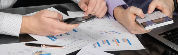 Hesap makinesi ve masadaki belgeleri arka plan üzerinde telefon ile Mens el