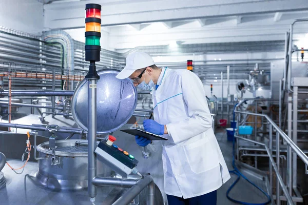 Man in a white robe and mask makes notes standing in the shop — Stock Photo, Image