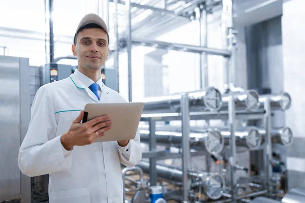Tecnólogo con una tableta en las manos en la planta láctea — Foto de Stock