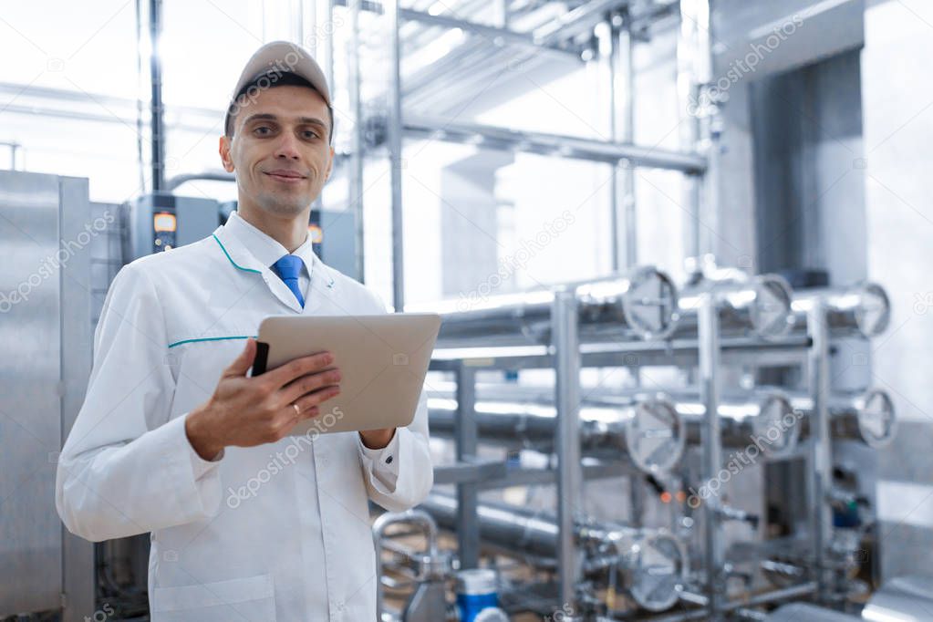 Technologist with a tablet in his hands at the dairy plant