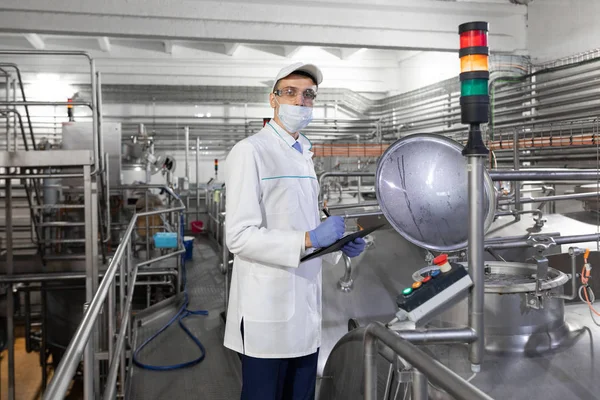 Technologist controls the production of dairy products At the plant — Stock Photo, Image