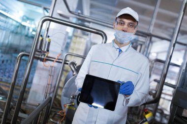 teknoloji uzmanı boş bir ekran tablet süt fabrikasında gösterir.