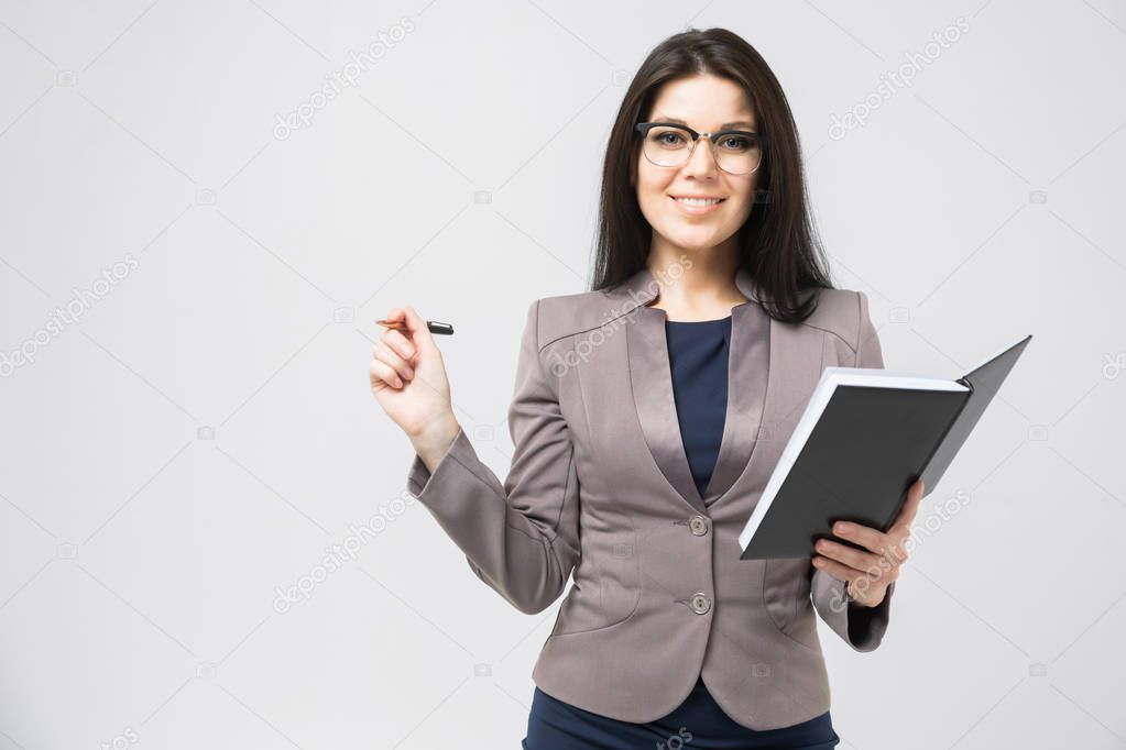 Portrait of a young girl with glasses with a diary in her hands isolated on a light background