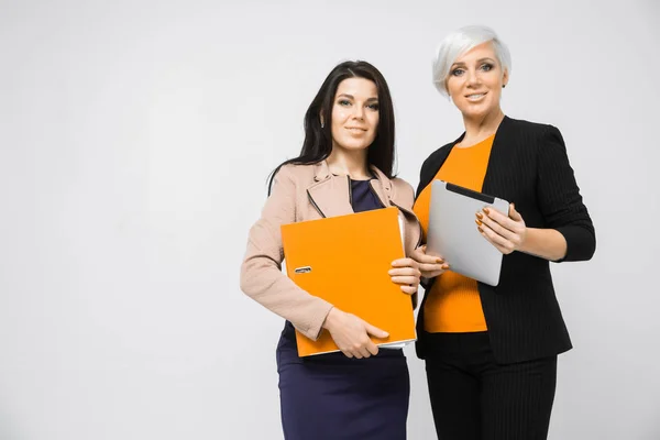 Portrait of two ladies with document folder and tablet in hand isolated on white background — Stock Photo, Image