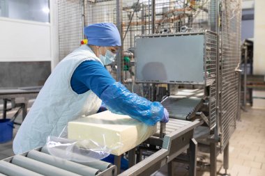 Worker packs butter at the dairy plant clipart