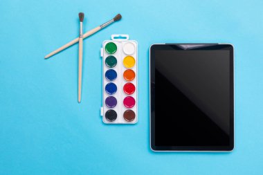 Suluboya boya ve fırça ile mavi arka plan tablete