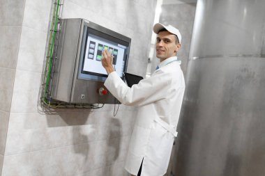adam beyaz bir elbise içinde ve bir kap dijital ekranın yakınındaysa standları