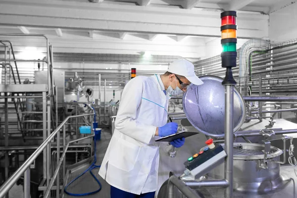 Technologist controls the production of dairy products At the plant — Stock Photo, Image