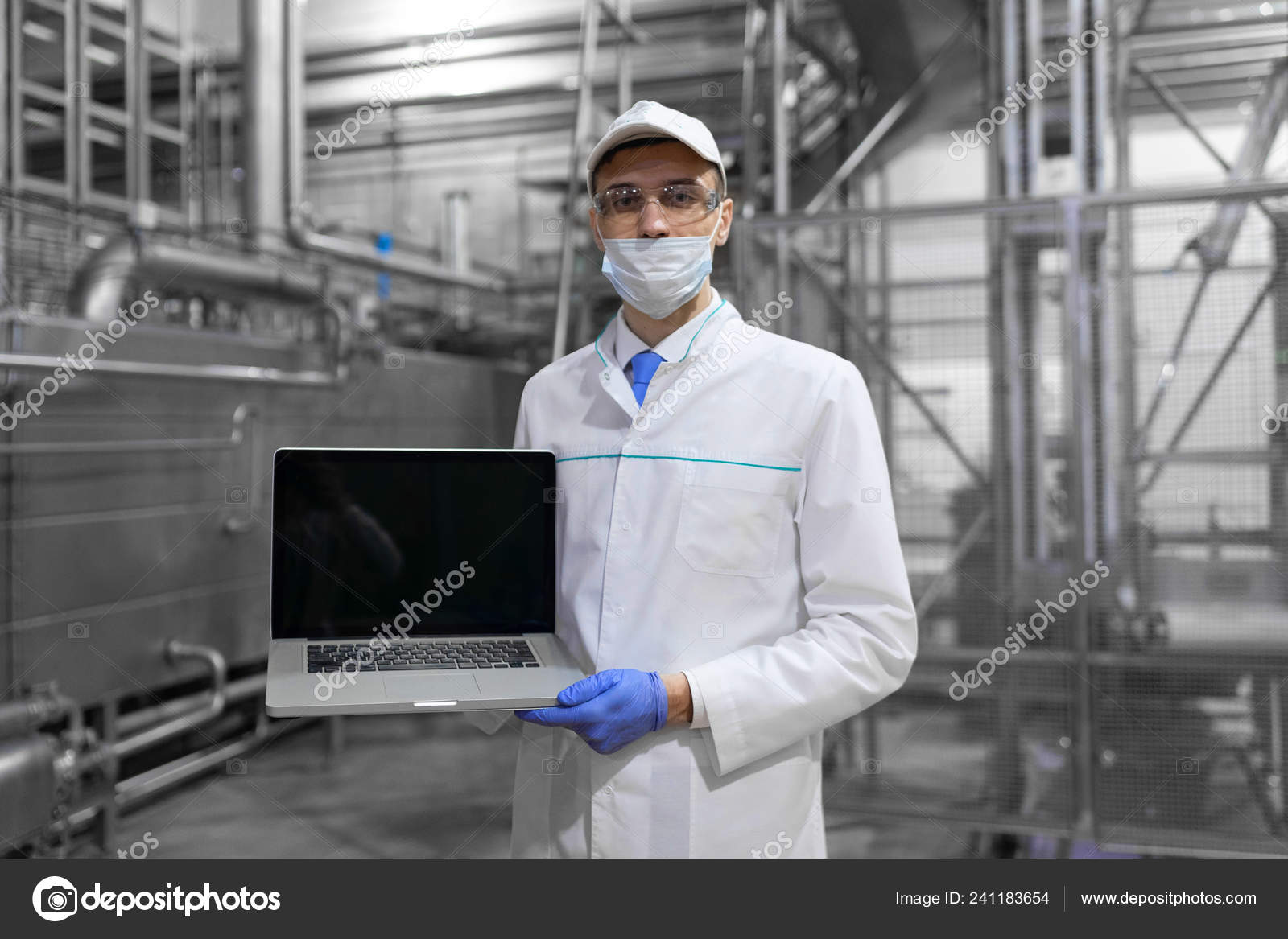 Man in a white robe and a mask with a laptop in his hands is at