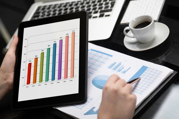 Närbild av handen håller tabletten och punkt penna på diagram — Stockfoto