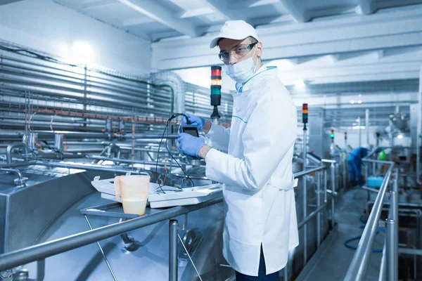 Hombre en una máscara y un albornoz conecta el dosímetro a la planta láctea — Foto de Stock