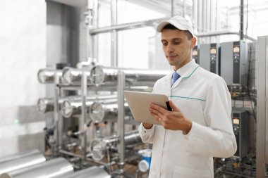Süt fabrikasında onun elinde bir tablet ile teknoloji uzmanı