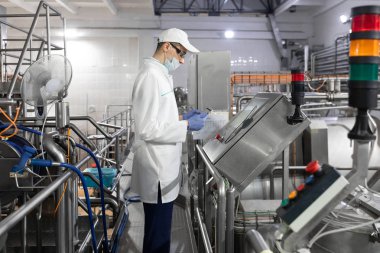 Dijital ekran süt fabrikasında yakındaki bir tablet ile teknoloji uzmanı duruyor