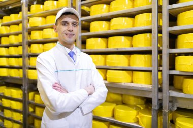 Adam rafları peynir süt fabrikasında arka plan üzerinde duruyor