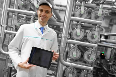 teknoloji uzmanı boş bir ekran tablet süt fabrikasında gösterir.