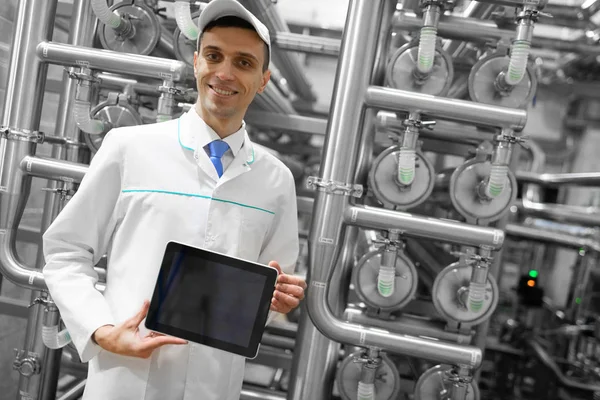 Технолог показывает чистый экран планшета на молочном заводе — стоковое фото