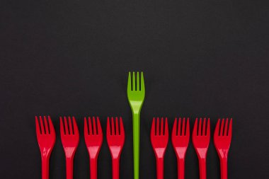 Tek kullanımlık kırmızı ve yeşil plastik çatal üzerinde arka izole
