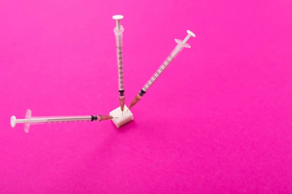 Белые медицинские шприцы торчат из куска сахара — стоковое фото