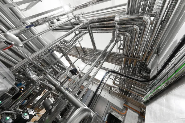 Stahlwasserleitung, Chromrohre, Rohrleitungen in der Werkhalle. industrieller Hintergrund — Stockfoto