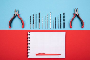 defter ve kalem renkli arka plan üzerinde ile metal işi araçlar kümesi