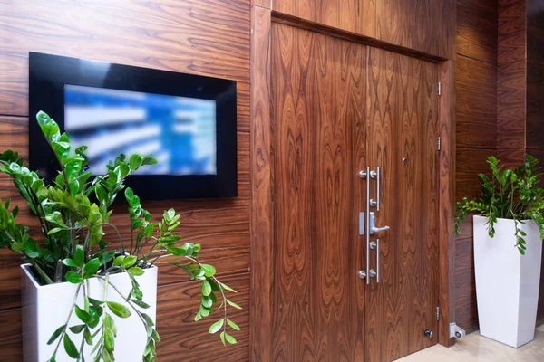 Monitora accanto alla porta di legno in un ufficio elegante — Foto Stock