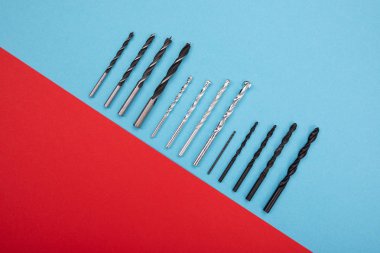 Dizi matkaplar yayılmış kırmızı-mavi zemin üzerine üst üste