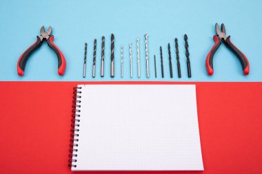 defter ve kalem renkli arka plan üzerinde ile metal işi araçlar kümesi
