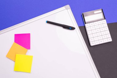 Defter, kalem ve mavi siyah arka plan üzerine izole hesap makinesi ile modern çalışma alanı