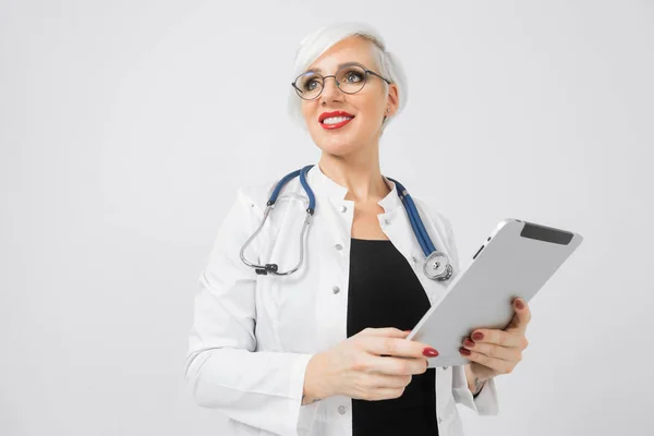 Sarışın kadınla elleri üzerinde arka izole tablet doktorlar kostüm portresi — Stok fotoğraf