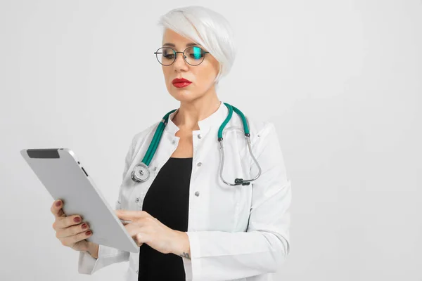 Sarışın kadınla elleri üzerinde arka izole tablet doktorlar kostüm portresi — Stok fotoğraf
