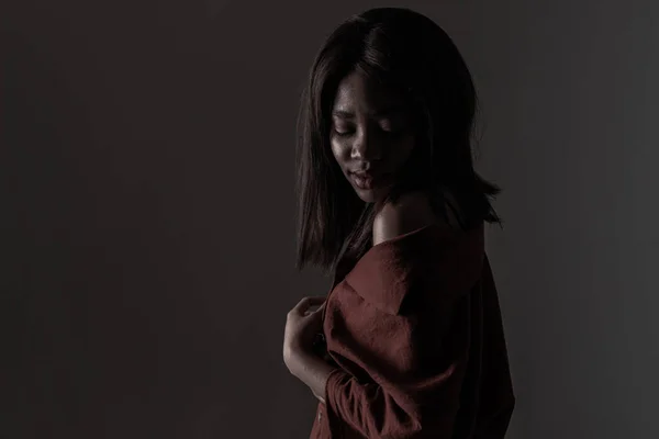 Portrait of a beautiful natural young African woman possing over black background