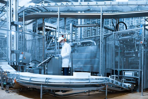 Hombre con una bata blanca y una gorra hacen una inspección de la línea de producción — Foto de Stock