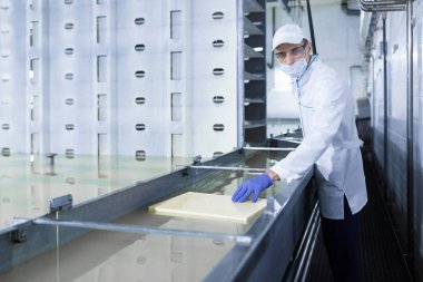 beyaz bir cüppe ve bir kap adam süt ürünleri bir denetim yapmak