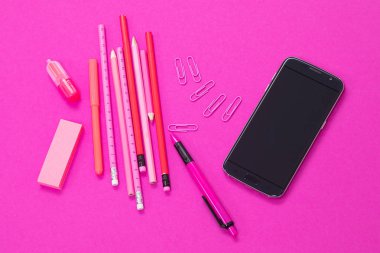Pembe renkli ofis gereklilikleri ve pembe arka plan kesim üzerinde bir siyah akıllı telefon
