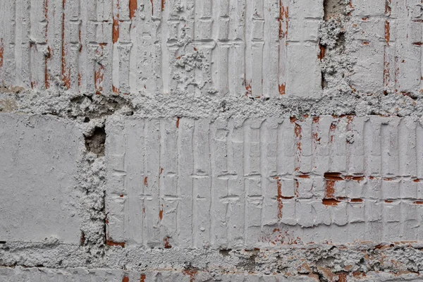 Un primer plano de una vieja pared de ladrillo cubierta de pintura gris —  Fotos de Stock