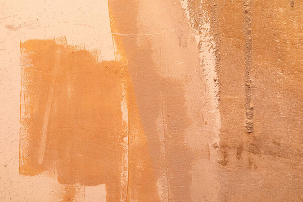 An orange unevenly painted beton wall