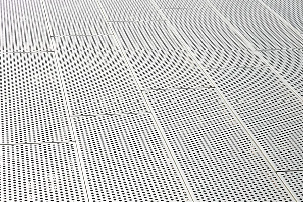 Vista diagonal de grelhas de metal e furos redondos na superfície de metal, painéis perfurados — Fotografia de Stock