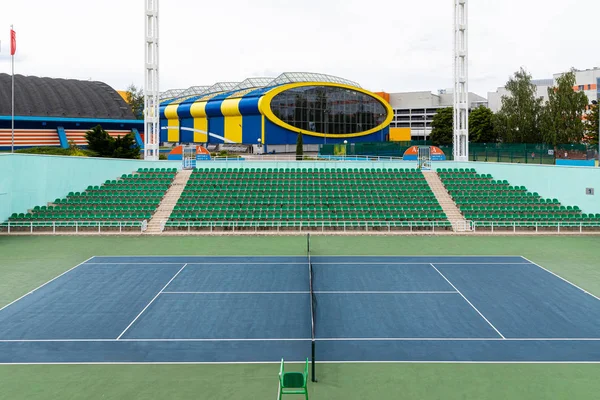 Utsikt over tennisbanen i åpent rom med bygning i tennissentrum i bakgrunnen – stockfoto