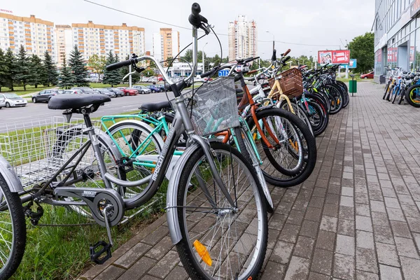 Minsk, Bielorrusia - 17 de julio de 2019: Expositor de bicicletas con muchas bicicletas sobre pavimentos húmedos — Foto de Stock
