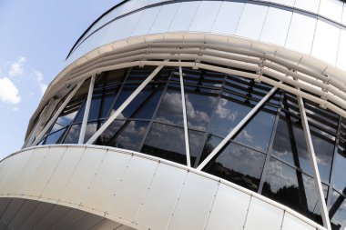 Caddeyi yansıtan beyaz binanın hemisferik siyah cam pencerelerinin dış görünümü