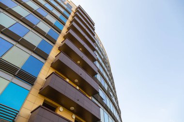 Pencere li ve kahverengi balkonlu bina duvarının mavi ve altın cam yüzeyinin zemin görünümü