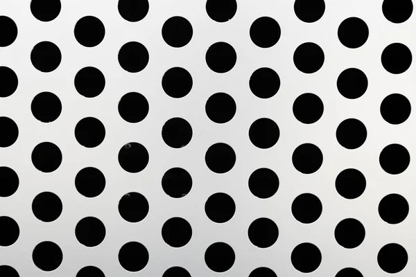 Rapid black big dot pattern on white background, round holes texture on perforated metal panel surface, close-up. — Stock Photo, Image