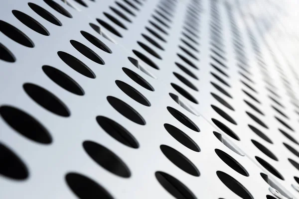 Rapid black big dot pattern on white background, round holes texture on perforated metal panel surface, angle view