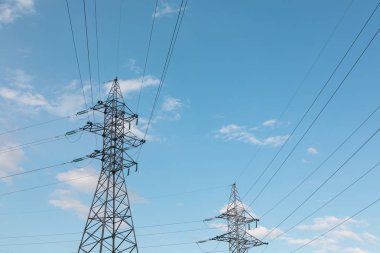 Gökyüzüne karşı telleri olan güç direklerinin siluetleri