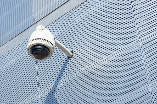 Close-up da câmera de vigilância na superfície de metal branco com um monte de pequenas aberturas redondas — Fotografia de Stock