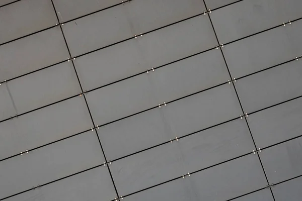 Diagonal close-up of light grey surface made of small metal tiles — Stock Photo, Image